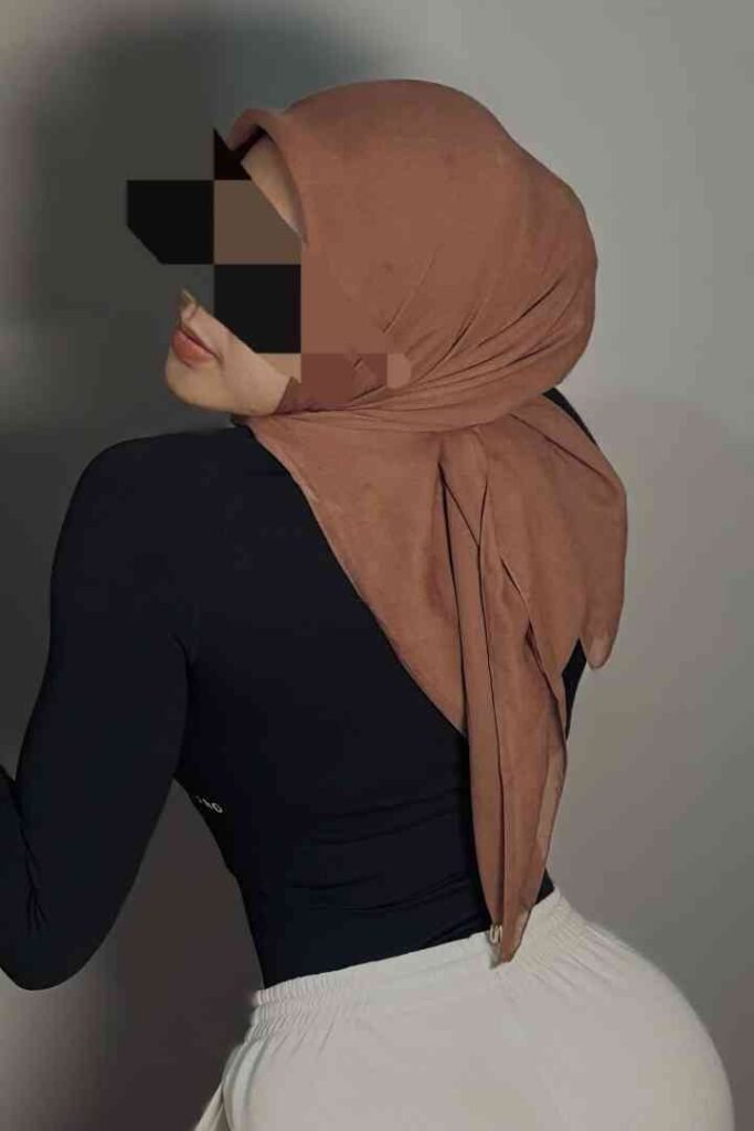 Woman in hijab and black top, white pants. Dila, Malay escort in KL, could be subtly referenced here.