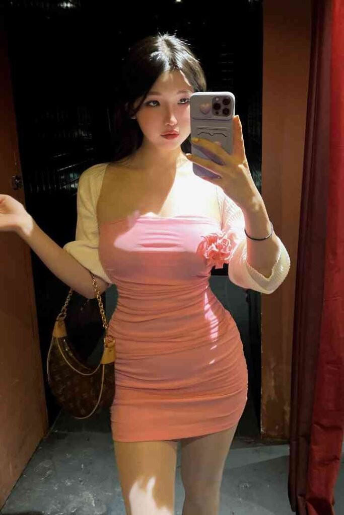 Nomin, exotic Mongolian beauty, in a pink dress takes a selfie.