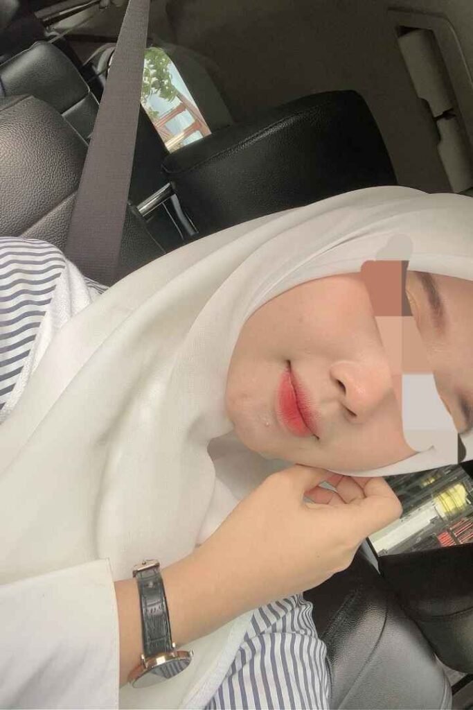 Malay woman in hijab with red lipstick in car. Eika, KL escort.